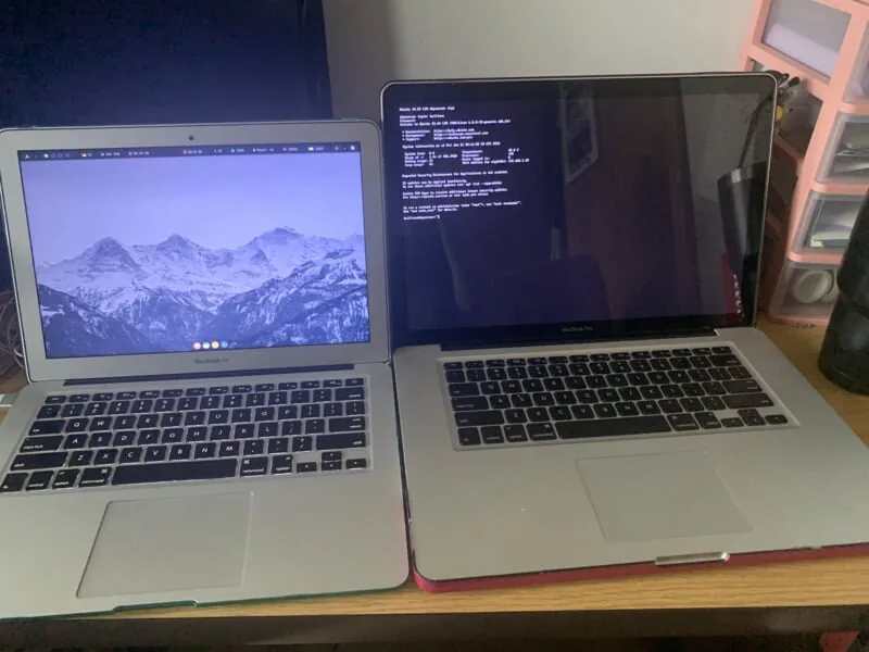 two laptops open on a desk. the left is a 13 inch macbook air and the right is a 15 inch macbook pro.